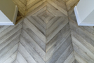 Dans l'entrée, le parquet chevron gris est inversé au milieu de la pièce